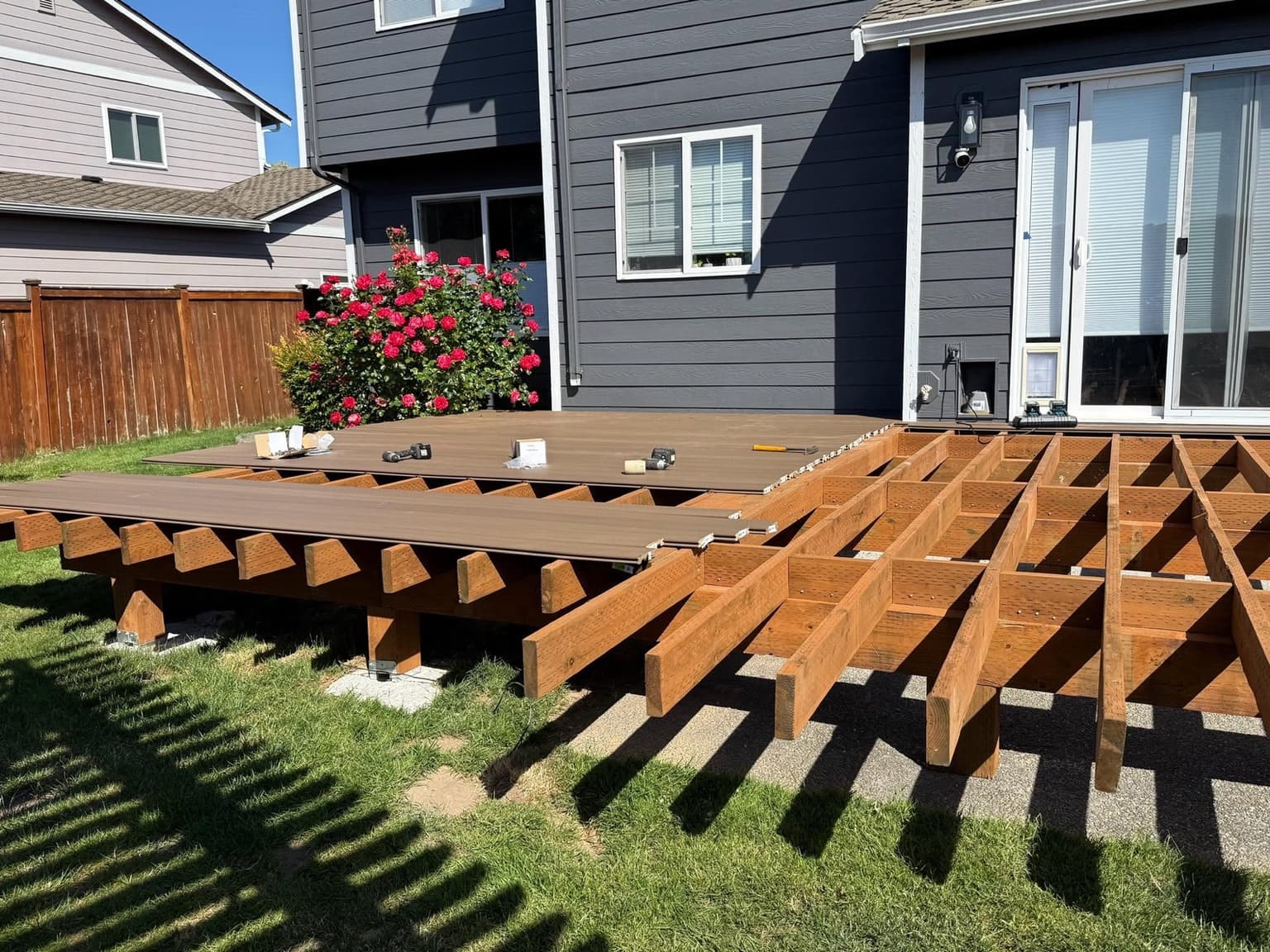 Pressure-treated deck joists and blocking with the first composite boards being installed using hidden fasteners